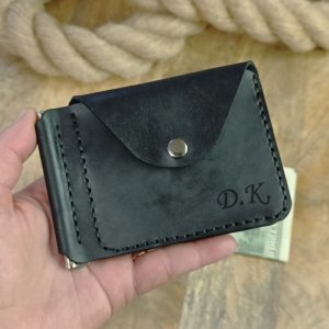 Portafoglio personalizzato con fermasoldi e tasca per monete e due tasche per carte di credito con incisione di iniziali e nomi, realizzato a mano in vera pelle nera. 
